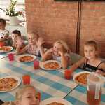 Warsztaty kulinarne - dzieci jedzą własnoręcznie przygotowaną pizzę
