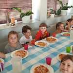 Warsztaty kulinarne- dzieci jedzą własnoręcznie przygotowaną pizzę