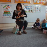 Spotkanie z pisarką- autorka prezentuje książkę, dzieci na dywanie