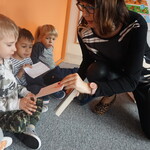 Spotkanie z pisarką- autorka prezentuje książkę, dzieci na dywanie