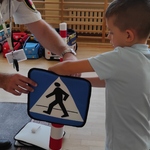 Bezpieczni na drodze- dziecko ustawia znak drogowy