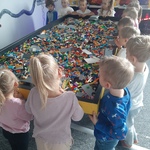 Wycieczka do sali zabaw z klockami Lego- dzieci przy stole z klockami Lego