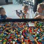 Wycieczka do sali zabaw z klockami Lego- dzieci przy stole z klockami Lego