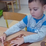 Światowy Dzień Pluszowego Misia- chłopiec wykonuje prace plastyczną