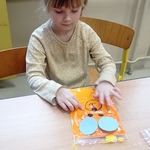 Światowy Dzień Pluszowego Misia- dziewczynka wykonuje prace plastyczną
