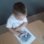 Międzynarodowy Dzień Praw Dziecka- chłopiec koloruje obrazek przy stoliku