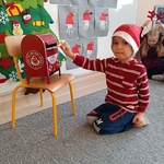 Mikołaj w przedszkolu- dziecko wrzuca list do skrzynki