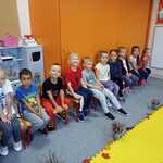 Pokaz Mody Jesiennej- dzieci siedzą na krzesełkach 