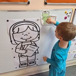 Międzynarodowy Dzień Praw Dziecka- chłopiec przyczepia obrazek do tablicy