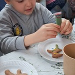 Jarmark Bożonarodzeniowy - dziecko dekoruje pierniczki