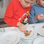 Jarmark Bożonarodzeniowy - dziecko dekoruje pierniczki