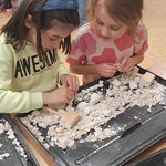 Warsztaty paleontologiczne - dziewczynki wydobywają dinozaura