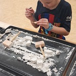 Warsztaty paleontologiczne - chłopiec wydobywa dinozaura