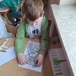 Międzynarodowy Dzień Matematyki- chłopiec przy stoliku dopasowuje 