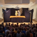 Teatr CoNieco w przedszkolu- aktor na scenie z lalka i dzieci na widowni