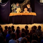 Teatr CoNieco w przedszkolu- aktorzy na scenie z lalkami i dzieci na widowni