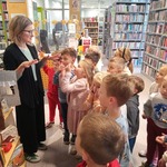 Jesienna wizyta Pszczółek w Książnicy Podlaskiej - dzieci słuchają p. bibliotekarki