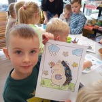 Jesienna wizyta Pszczółek w Książnicy Podlaskiej - dziecko ze swoją pracą plastyczną