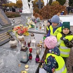 Wyjście na cmentarz - dzieci ustawiają znicze
