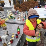 Wyjście na cmentarz - dziecko stawia znicz