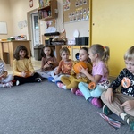 Dzień Dyni w grupie Słoneczka  - dzieci na dywanie poddają sobie dynie
