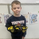 Dzień LEGO w przedszkolu- dziecko z budowla samochodem z klocków