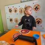 Dzień pizzy - dziewczynka komponuje pizzę