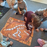 W świecie dinozaurów- dzieci układają szkielet dinozaura na planszy