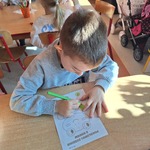 Światowy dzień żabki - dziecko koloruje przy stoliku