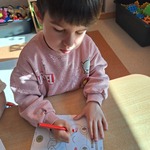 Światowy dzień żabki - dziecko koloruje przy stoliku