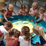 dzieci budują z kolorowego piasku