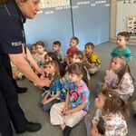 Policjantki w przedszkolu- funkcjonariuszka demonstruje dzieciom kajdanki