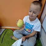 Dzień jabłka w naszym przedszkolu- dziecko ogląda jabłko