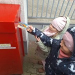 Dzień Poczty Polskiej- dzieci wrzucają pocztówkę do skrzynki 