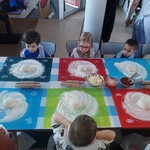 Warsztaty kulinarne - dzieci siedzą przy stole