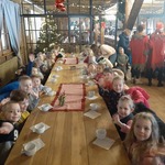 Z wizytą u świętego Mikołaja -dzieci przy stolei