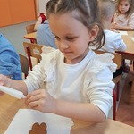 Coraz bliżej święta, coraz bliżej święta... - dziewczynka dekoruje pierniczka