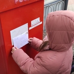 Dzień Poczty Polskiej- dziewczynka wrzuca list do skrzynki
