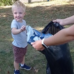 Sprzątanie świata- dziecko wrzuca śmieci do worka